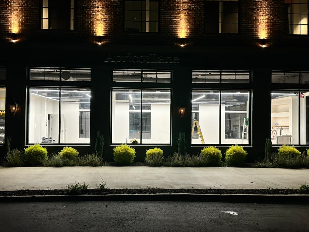 Retail boutique storefront with bright LED interior and warm exterior accent lighting after upgrade